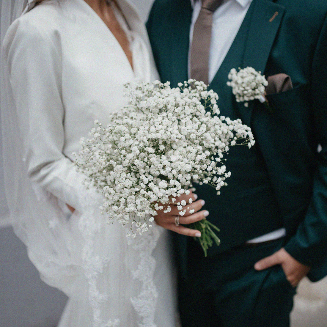 Couple de mariés avec un bouquet de fleurs blanches